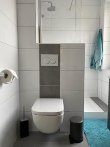 a white bathroom with a toilet and a shower at Kajüte 19 in Emden