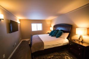 a bedroom with a bed with blue pillows on it at Clipperton Suite by Revelstoke Vacations in Revelstoke