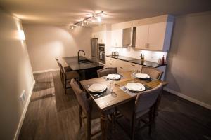 a kitchen and dining room with a wooden table and chairs at Clipperton Suite by Revelstoke Vacations in Revelstoke