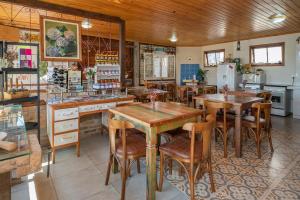 a restaurant with wooden tables and chairs in a room at Pousada Flor de Tuna in Urubici