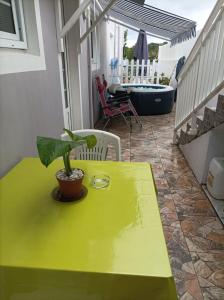 une table verte avec une plante en pot sur une terrasse dans l'établissement VILLA AU COEUR DE LA MARMITE, à Sainte-Marie