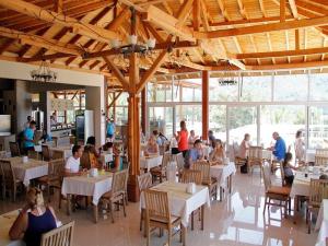 a group of people sitting at tables in a restaurant at Nicholas Park Hotel in Fethiye