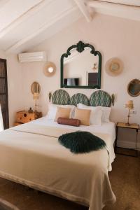 1 dormitorio con 1 cama grande y espejo grande en la pared en Posada Morisca Charming Hotel Boutique, en Frigiliana