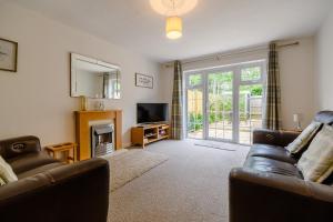 a living room with two leather couches and a television at Morris Road in Broadway