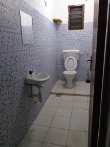 a bathroom with a toilet and a sink at Hyven's Apartments in Mtwapa