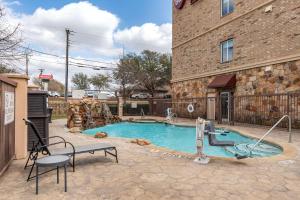 a swimming pool in front of a building at Best Western Plus DFW Airport West Euless in Euless