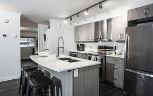 a kitchen with a sink and a refrigerator at Novlan Suite by Revelstoke Vacations in Revelstoke
