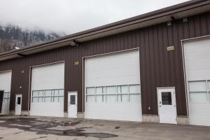 a brown building with four white garage doors at Novlan Suite by Revelstoke Vacations in Revelstoke
