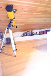 a camera on a tripod in a room with a book shelf at A Toca in Nordeste