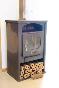 a wood stove with logs in front of it at A Toca in Nordeste