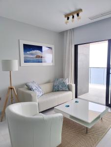 ein Wohnzimmer mit einem Sofa und einem Couchtisch in der Unterkunft SUNSET WAVES sea & sky apartment in Benidorm