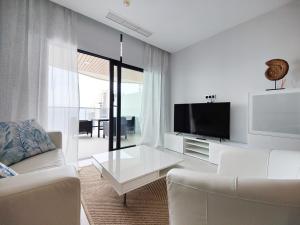 a living room with a couch and a tv at SUNSET WAVES sea & sky apartment in Benidorm