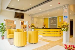 un vestíbulo de tienda con sillas amarillas y un mostrador en Mercé Hotel, en Tacna