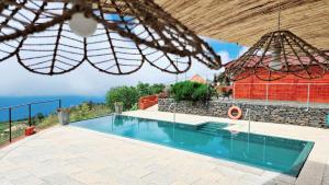 une villa avec une piscine et un bâtiment dans l'établissement Madeira Sunset Cottage - Nature Retreat, à Ponta do Pargo