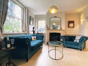 een woonkamer met een blauwe bank en een open haard bij Manor House of Cheshunt- Historic Villa in Cheshunt
