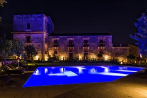 un grande edificio con piscina blu di notte di Borgo del Carato a Solarino