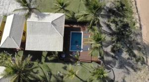 an aerial view of a house with palm trees at Villa do Sossego - Caraíva in Caraíva