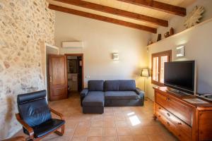 ein Wohnzimmer mit Sofa und Fernseher in der Unterkunft Ca n Batlet in Inca