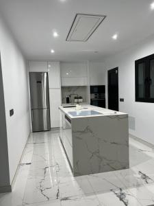 a kitchen with marble counter tops and a refrigerator at Agradable Bungalow con Piscina in Playa del Ingles