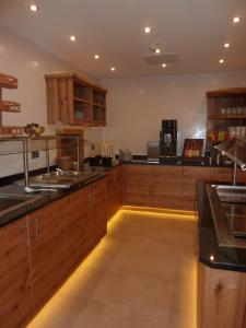 a large kitchen with wooden cabinets and counters at Alpenflair Hotel in Buchloe