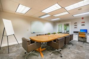 uma sala de conferências com uma mesa de madeira e cadeiras em La Residence Suite Hotel em Bellevue