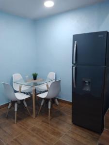 a dining room with a table and a black refrigerator at Paulino in Santiago de los Caballeros