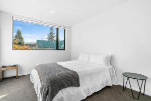 Habitación blanca con cama y ventana en Mountain Vistas - Cromwell Upstairs Apartment, en Cromwell