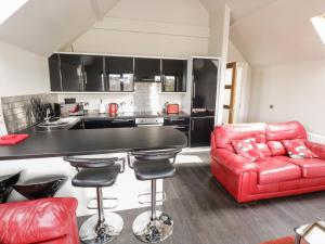 Doirí BeagaにあるDerrybeg Apartmentのリビングルーム(赤いソファ付)、キッチン