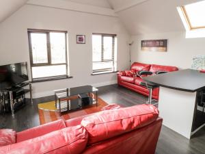 Doirí BeagaにあるDerrybeg Apartmentのリビングルーム(赤い革張りのソファ、テーブル付)