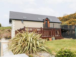 a home with a large deck and a house at Derrybeg Apartment in Doirí Beaga