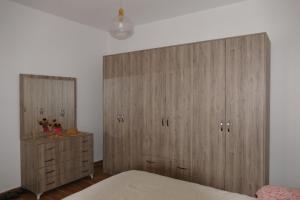 um quarto com armários de madeira, uma cama e uma cómoda em Villa Panorama Ishem em Durrës