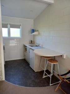 una pequeña cocina con fregadero y mesa en Tower Road Motel, en Matamata