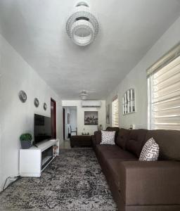 sala de estar con sofá y TV de pantalla plana en Casa espaciosa con Jacuzzi, área sur PR, en Juana Díaz