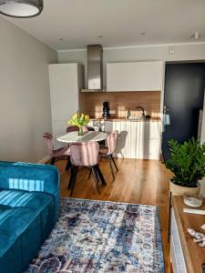 a living room with a blue couch and a table at Seaside bungalow Juura at Albatross, Kesterciems with garden, Spa and pool for extra in Ķesterciems