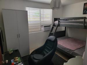 ein kleines Zimmer mit einem Etagenbett und einem Stuhl in der Unterkunft Casa espaciosa con Jacuzzi, área sur PR in Juana Díaz