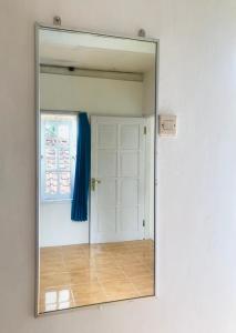 a mirror reflection of a door with a blue curtain at TURU Homestay Syariah in Banjarnegara