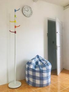 a room with a clock on the wall and a stool at TURU Homestay Syariah in Banjarnegara +2 photos