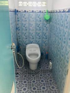 a bathroom with a toilet with a blue tiled floor at TURU Homestay Syariah in Banjarnegara