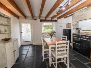 cocina con mesa de madera y sillas en Silver Hill Cottage, en Harrogate