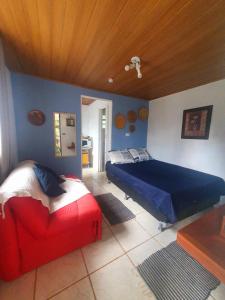 een slaapkamer met een bed en een bank erin bij Kitnet no Sul de Minas in Soledade de Minas