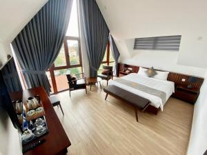 大叻的住宿－Duy Long Hotel，卧室配有一张床和一张桌子及椅子