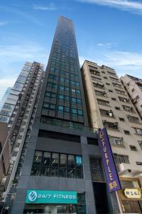 um edifício alto com um sinal em frente em Hotel Purple Hong Kong em Hong Kong