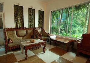 a living room with a couch and a table and windows at Tan Kang Angkor Hotel in Siem Reap