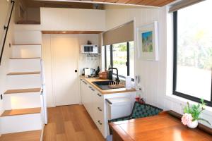 a tiny house with a kitchen and a staircase at The Pink Lake Tiny House - 'Sakura' in Lochiel