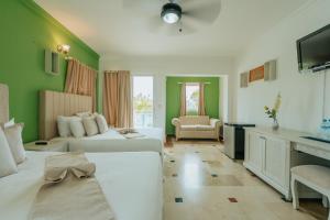 una camera d'albergo con due letti e una televisione di Green Coast Hotel a Punta Cana