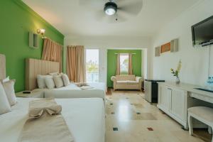 a hotel room with two beds and a television at Green Coast Hotel in Punta Cana