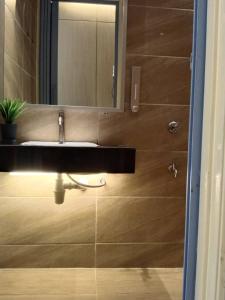 a bathroom with a sink and a mirror at ezzahrahsyariahhomestay in Sandakan