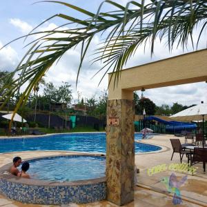 dos personas en una piscina en un complejo en LINDO ALOJAMIENTO ARMENIA, QUINDIO, EJE CAFETERO, en La Tebaida