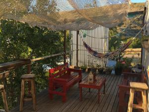 una terraza con sillas y una hamaca. en La Ventolina, en Puerto Pirámides