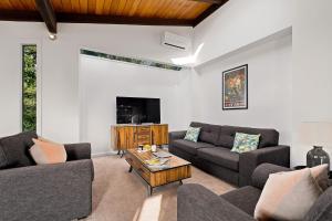 a living room with two couches and a coffee table at Queenstown Lakefront Dream 4 Bed in Queenstown